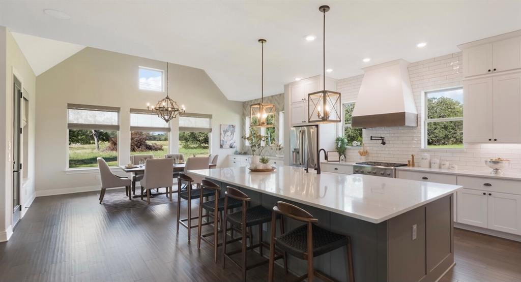Lot 12 Ridgeway Trail Johnson City, TX 78636 - Photo 4 of 26 a kitchen with stainless steel appliances granite countertop a sink a stove and a wooden floors