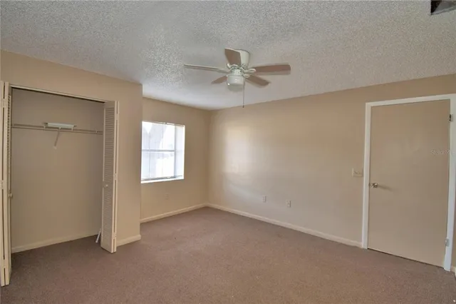 an empty room with windows and fan