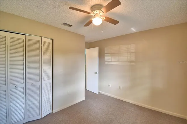 an empty room with a ceiling fan and a window