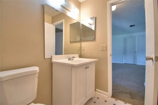 a bathroom with a sink a toilet and mirror