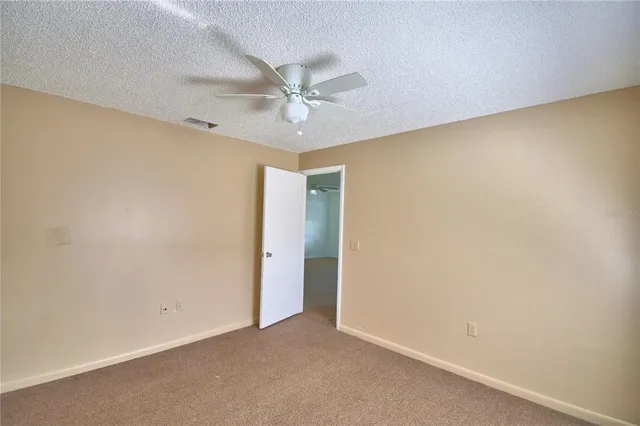 an empty room with a ceiling fan and a window