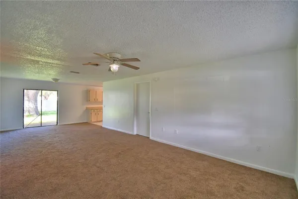an empty room with windows and ceiling fan view
