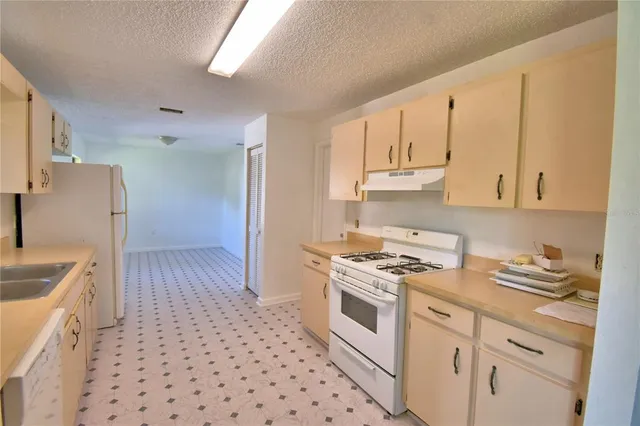 a kitchen with granite countertop white cabinets and white appliances