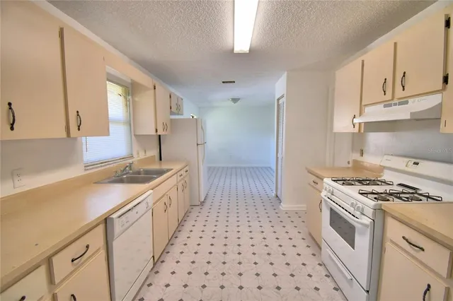 a kitchen with granite countertop a stove sink and cabinets