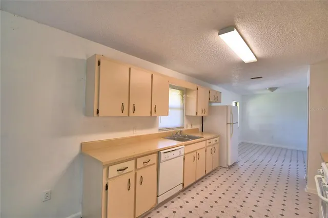a kitchen that has a sink and a stove in it