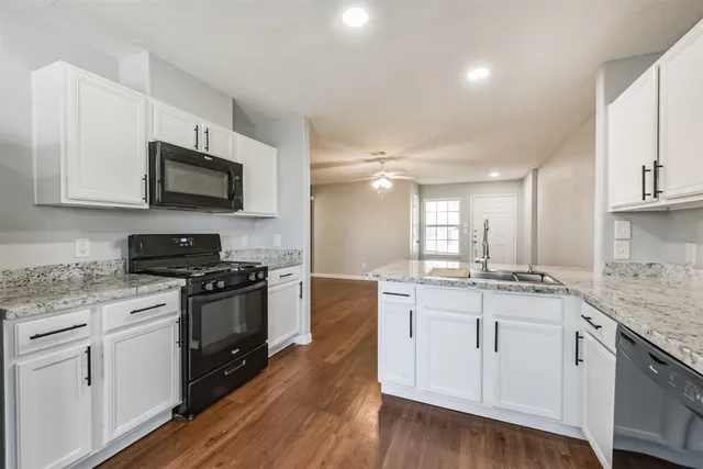 a kitchen with granite countertop a sink and steel appliances