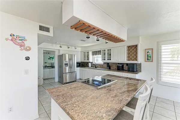 a kitchen with kitchen island granite countertop a stove and a sink