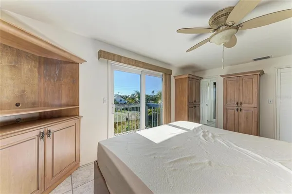 a bedroom with a large bed and a chandelier fan