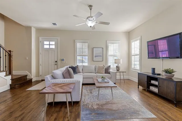 a living room with furniture a table and wooden floor