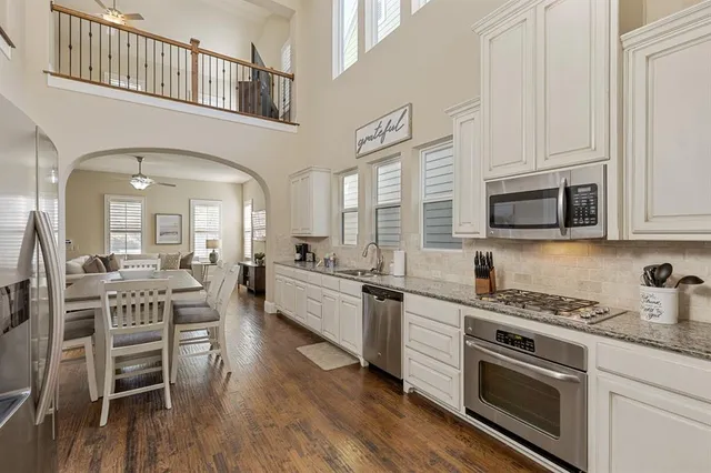 a kitchen with stainless steel appliances a white stove top oven and cabinets
