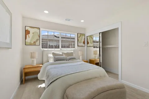a bedroom with a bed and a refrigerator