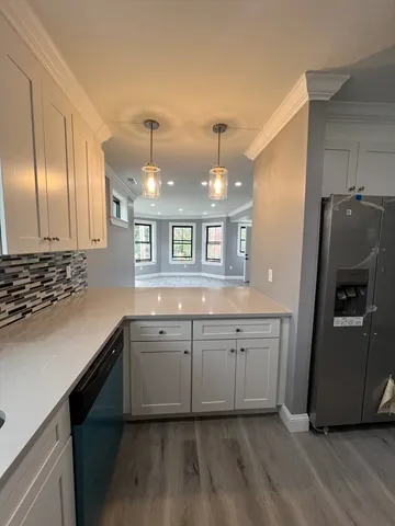 a large kitchen with a sink and dishwasher a refrigerator with wooden floor