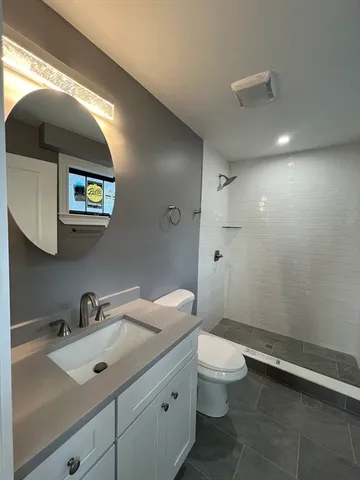 a bathroom with a sink vanity mirror and toilet