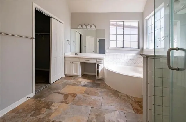 a spacious bathroom with a mirror and bathtub