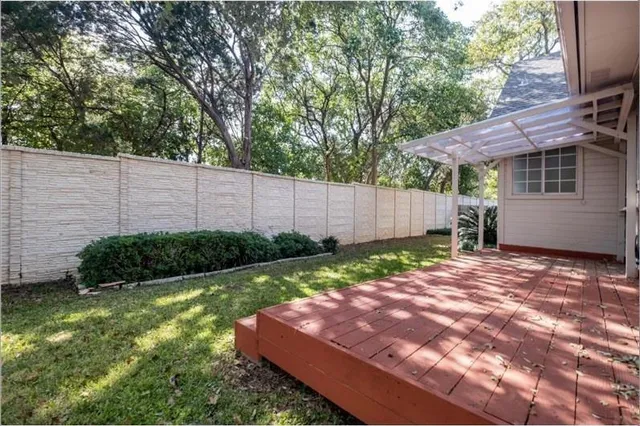 a view of a backyard with plants and a fence