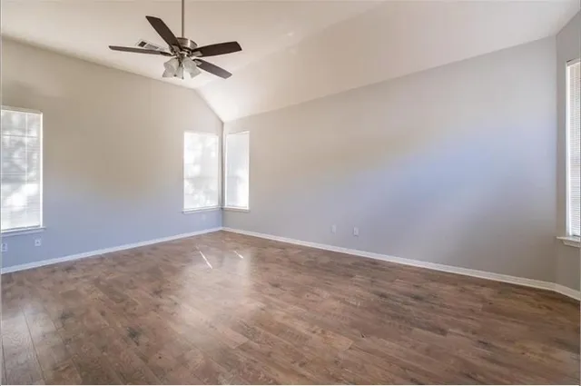 an empty room with windows and fan