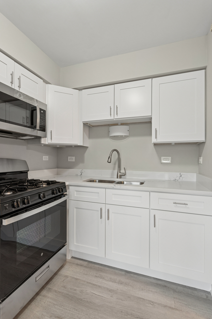 4 Tower Court Downers Grove, IL 60516 - Photo 8 of 20 a kitchen with granite countertop white cabinets and stainless steel appliances