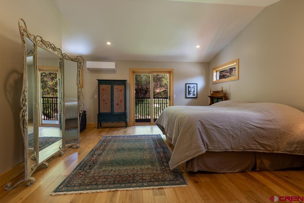 7041 County Road 203 Durango, CO 81301 - Photo 30 of 45 a spacious bedroom with a large bed couch and a window