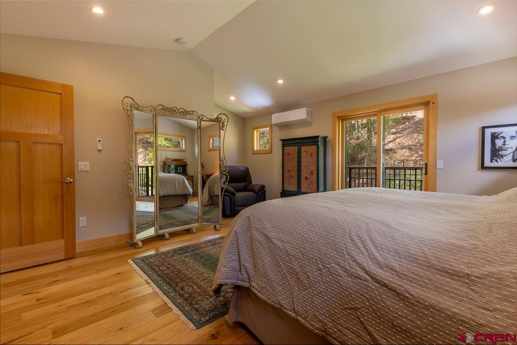 7041 County Road 203 Durango, CO 81301 - Photo 31 of 45 a spacious bedroom with a large bed a chandelier and dresser