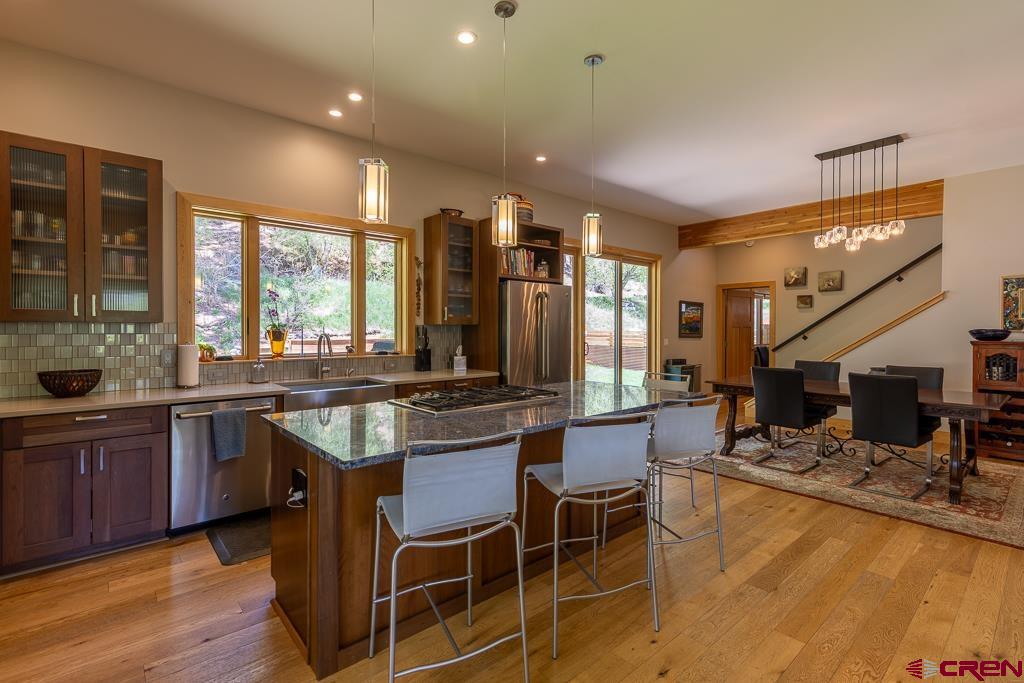 7041 County Road 203 Durango, CO 81301 - Photo 6 of 45 a kitchen with stainless steel appliances granite countertop sink stove and wooden cabinets