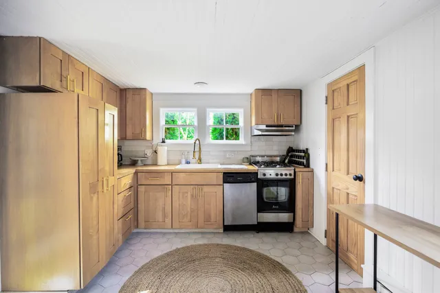 a kitchen with stainless steel appliances granite countertop a refrigerator sink and stove