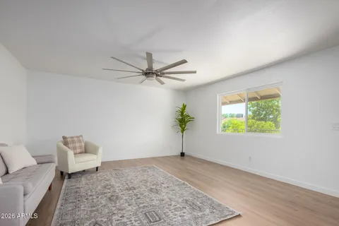 an empty room with window and ceiling fan