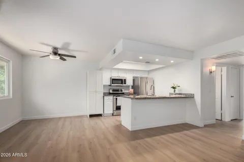 a kitchen with kitchen island granite countertop a sink a stove and a refrigerator