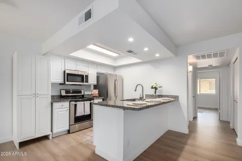 a kitchen with stainless steel appliances granite countertop a refrigerator stove and microwave