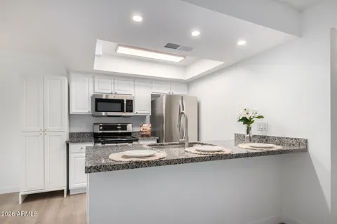 a kitchen with kitchen island granite countertop a sink and a granite counter tops