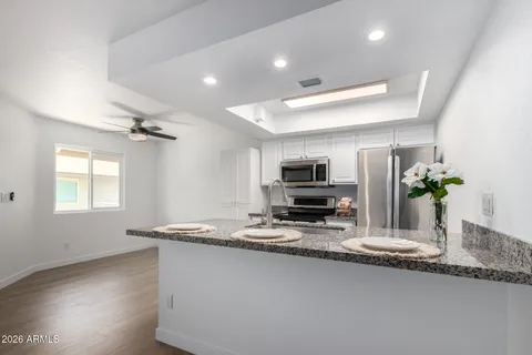 an empty room with ceiling fan and windows
