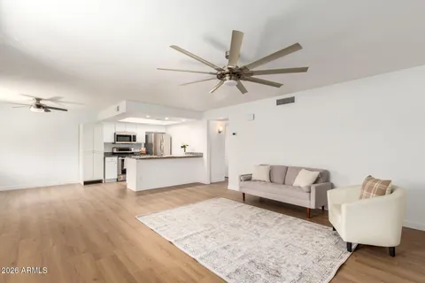 a kitchen with granite countertop a sink cabinets and wooden floor
