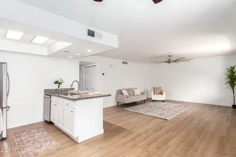 a kitchen with kitchen island granite countertop stainless steel appliances a sink stove refrigerator and cabinets