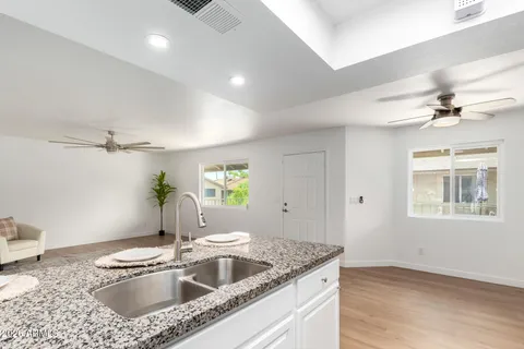 a kitchen with granite countertop a sink appliances and cabinets