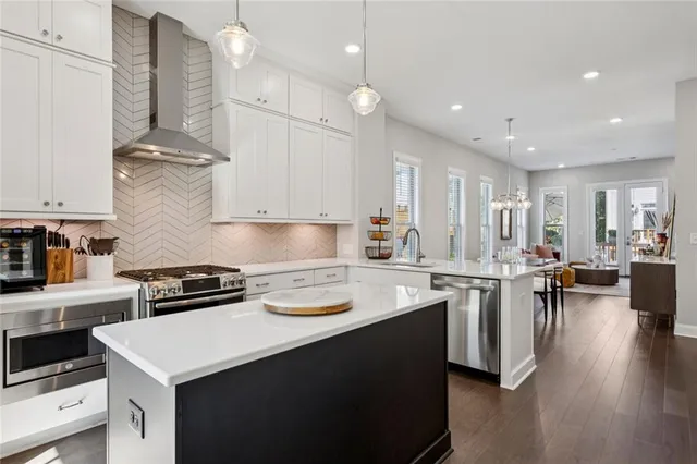a kitchen with a stove a refrigerator and a dining table with wooden floor