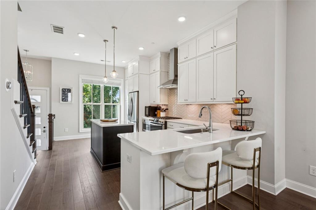 4219 Deming Circle Sandy Springs, GA 30342 - Photo 11 of 40 a kitchen with stainless steel appliances granite countertop a stove a sink a refrigerator and a dining table with wooden floor