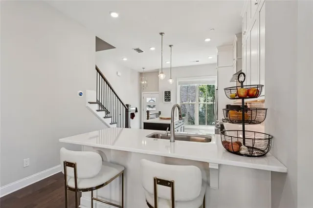 a kitchen with stainless steel appliances kitchen island granite countertop a table chairs and a refrigerator