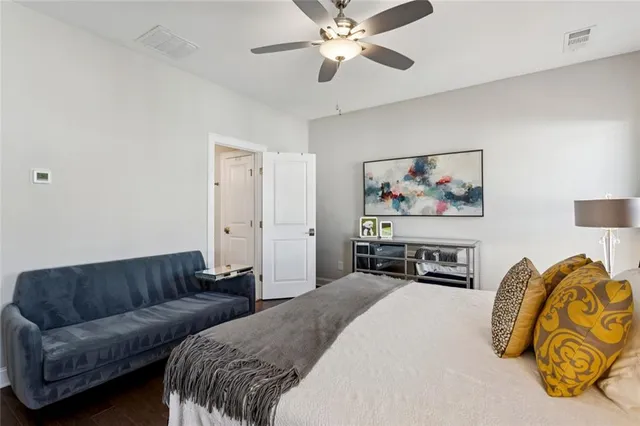 a spacious bedroom with a bed a couch and a chandelier