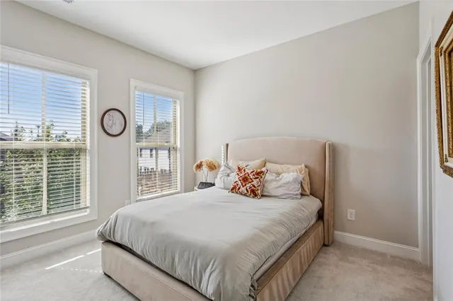 a bedroom with a large bed and windows