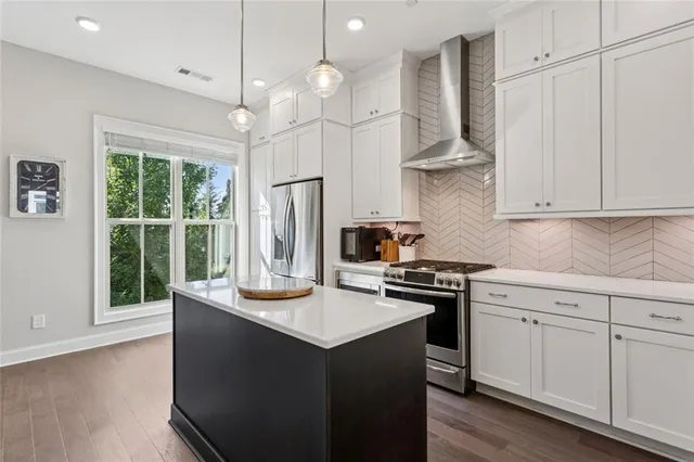 a kitchen with kitchen island granite countertop a stove a sink a center island and cabinets