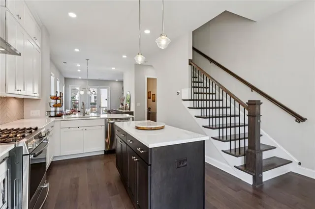 a kitchen with white cabinets appliances and a center island
