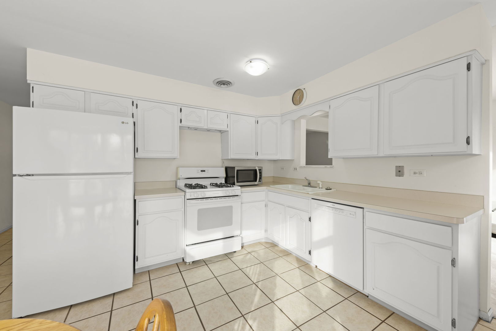 1308 Stonegate Road Naperville, IL 60540 - Photo 7 of 30 a kitchen with white cabinets and white appliances