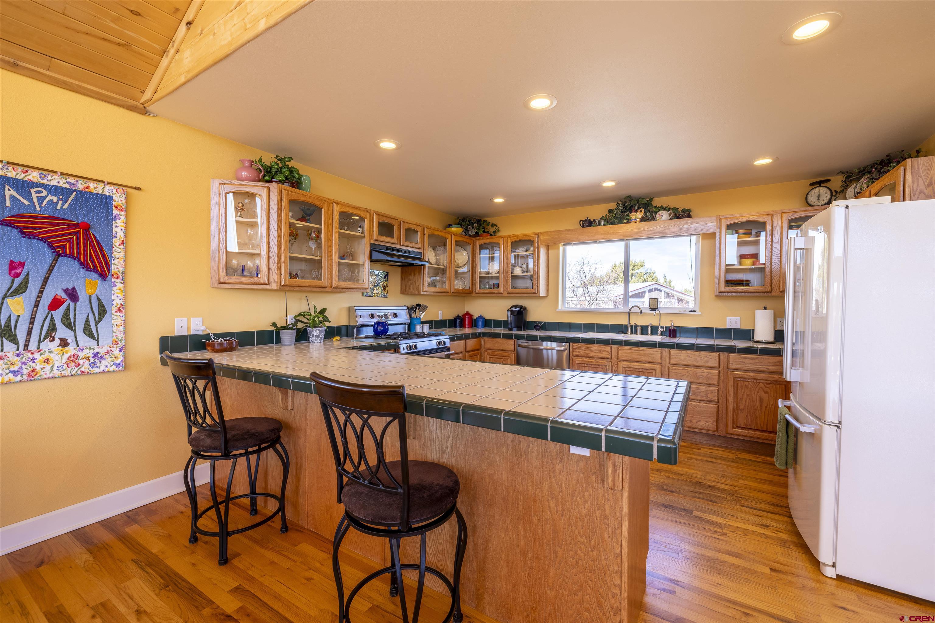 63 Sagewood Drive Ignacio, CO 81137 - Photo 10 of 33 a kitchen with stainless steel appliances granite countertop table chairs and wooden floor