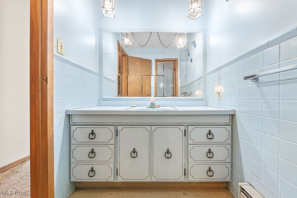 1165 Homeworth Road Alliance, OH 44601 - Photo 28 of 36 Bathroom with vanity, a baseboard heating unit, and tile walls