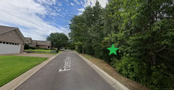 a view of a street with a big yard