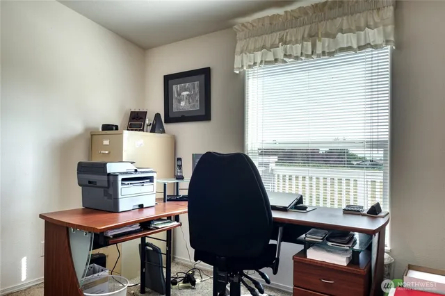 a view of a workspace with furniture and a window
