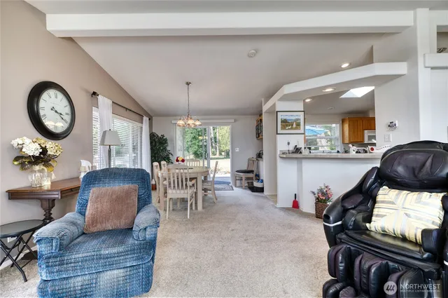 a living room with furniture a chandelier couches and a large window