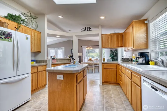a kitchen with stainless steel appliances granite countertop a sink and a refrigerator