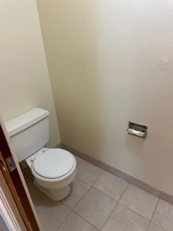 a white toilet sitting next to a white wall