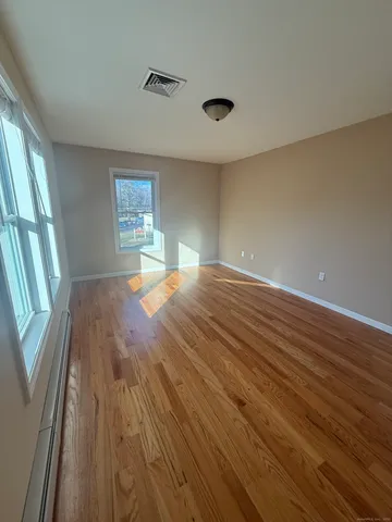 wooden floor in an empty room with a window
