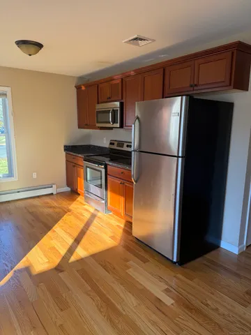 a kitchen with granite countertop a refrigerator and a stove top oven